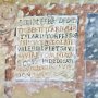 Particolare degli affreschi: la targa con dedicazione a S. Ilario
